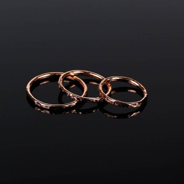 3 hammered copper stacking rings on black background