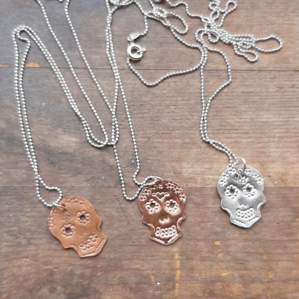 sugar skull necklaces on wooden background