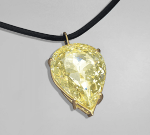 the moon of baroda diamond - a light yellow pear shaped diamond set in gold claw setting on a leather cord