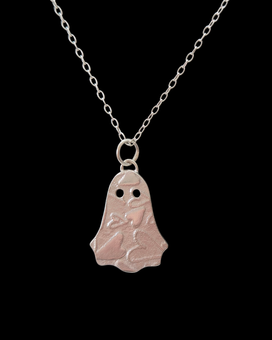 silver ghost necklace on back background