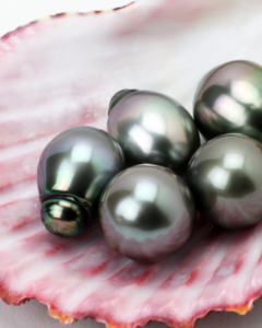 Iridescent purple, green and black pearls on a pink shell