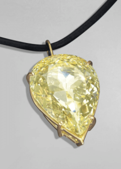 the moon of baroda diamond - a light yellow pear shaped diamond set in gold claw setting on a leather cord